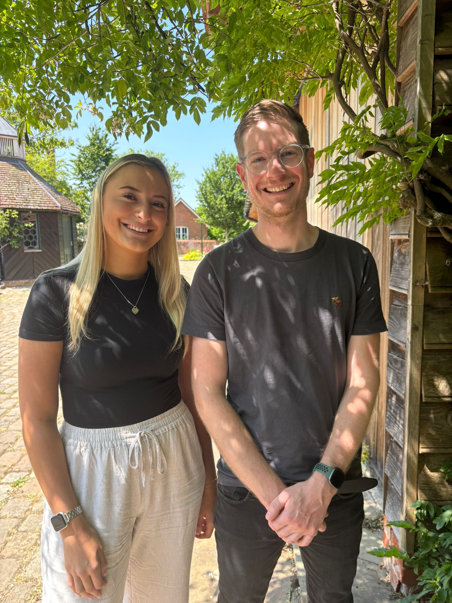 Two team members stood under a tree
