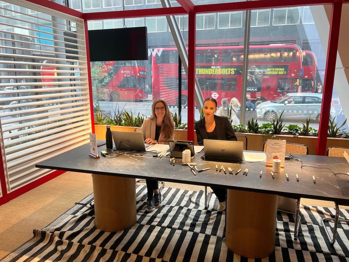 Two team members in an office in front of laptops
