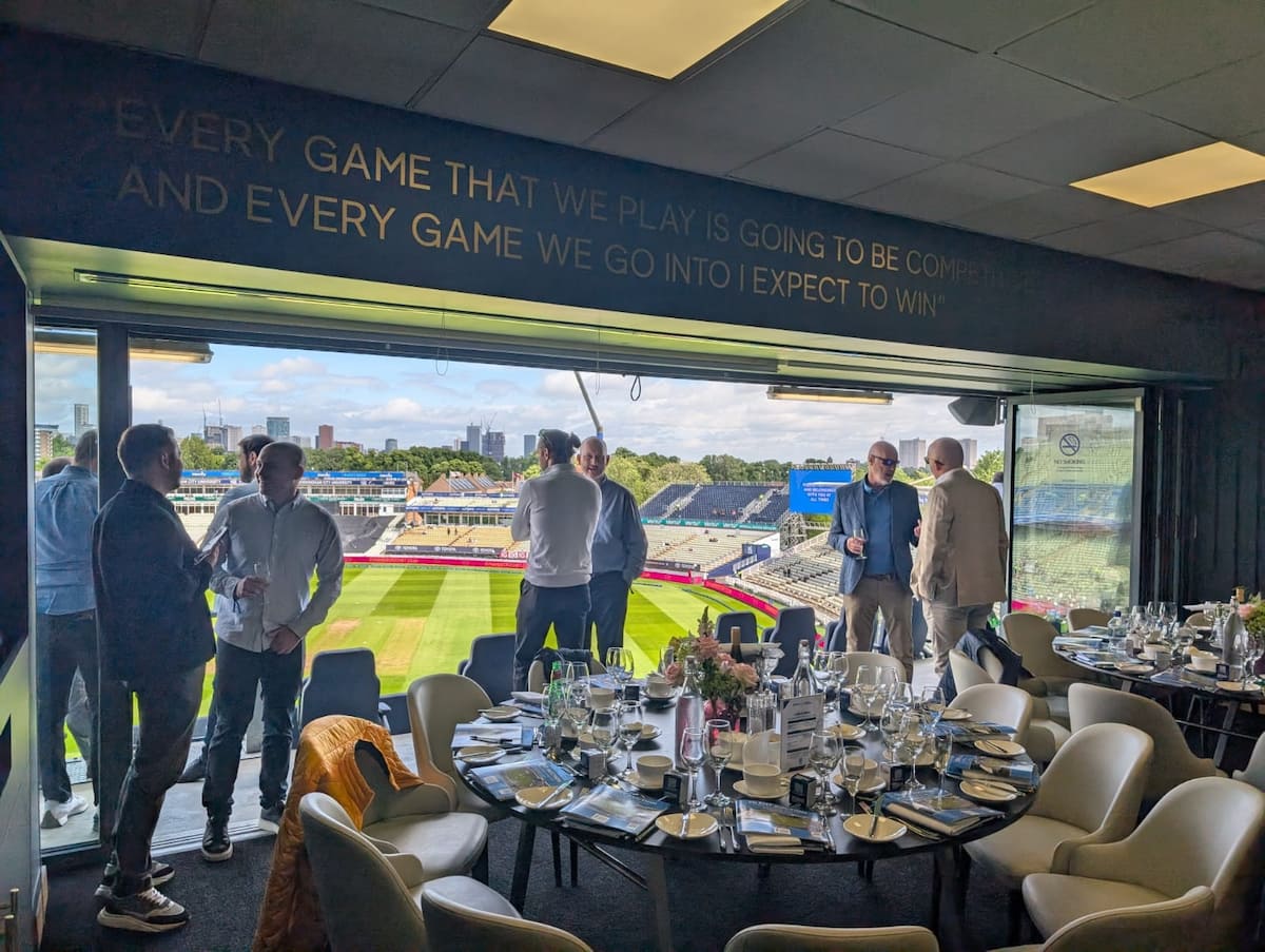 People in a box at football stadium with dining tables