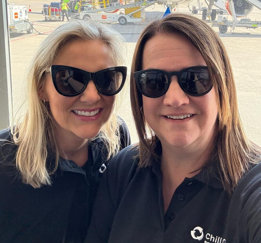 Two team members in sunglasses at an airport