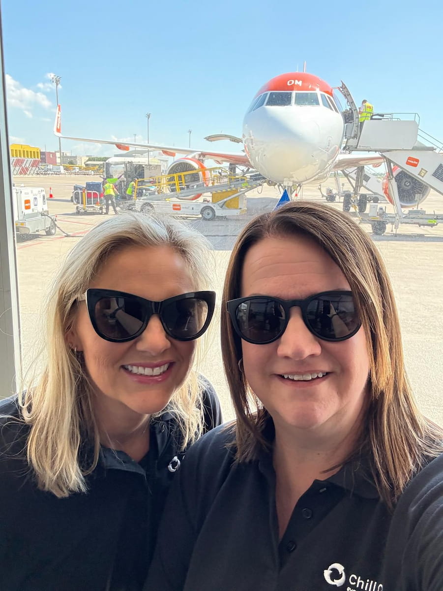 Two team members in sunglasses at an airport