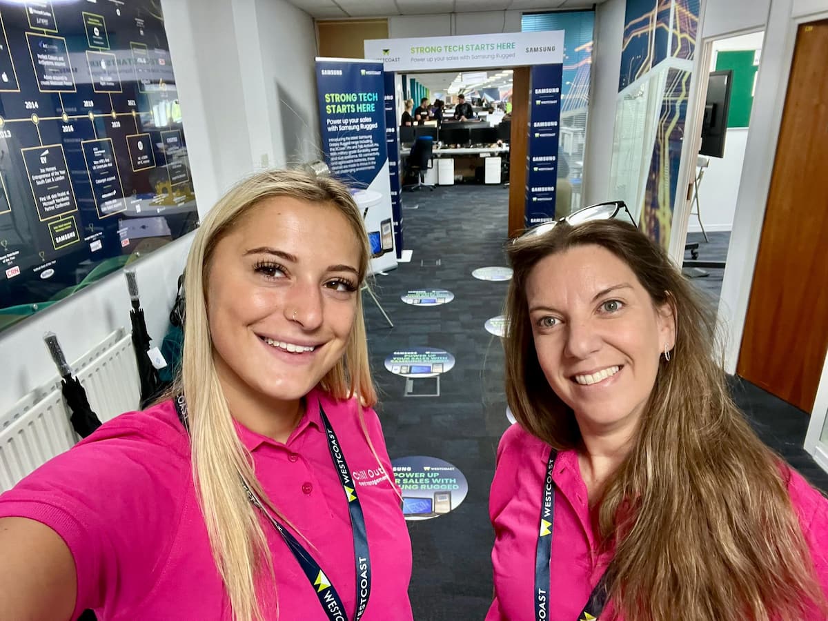 Two team members in pink shirts at an event